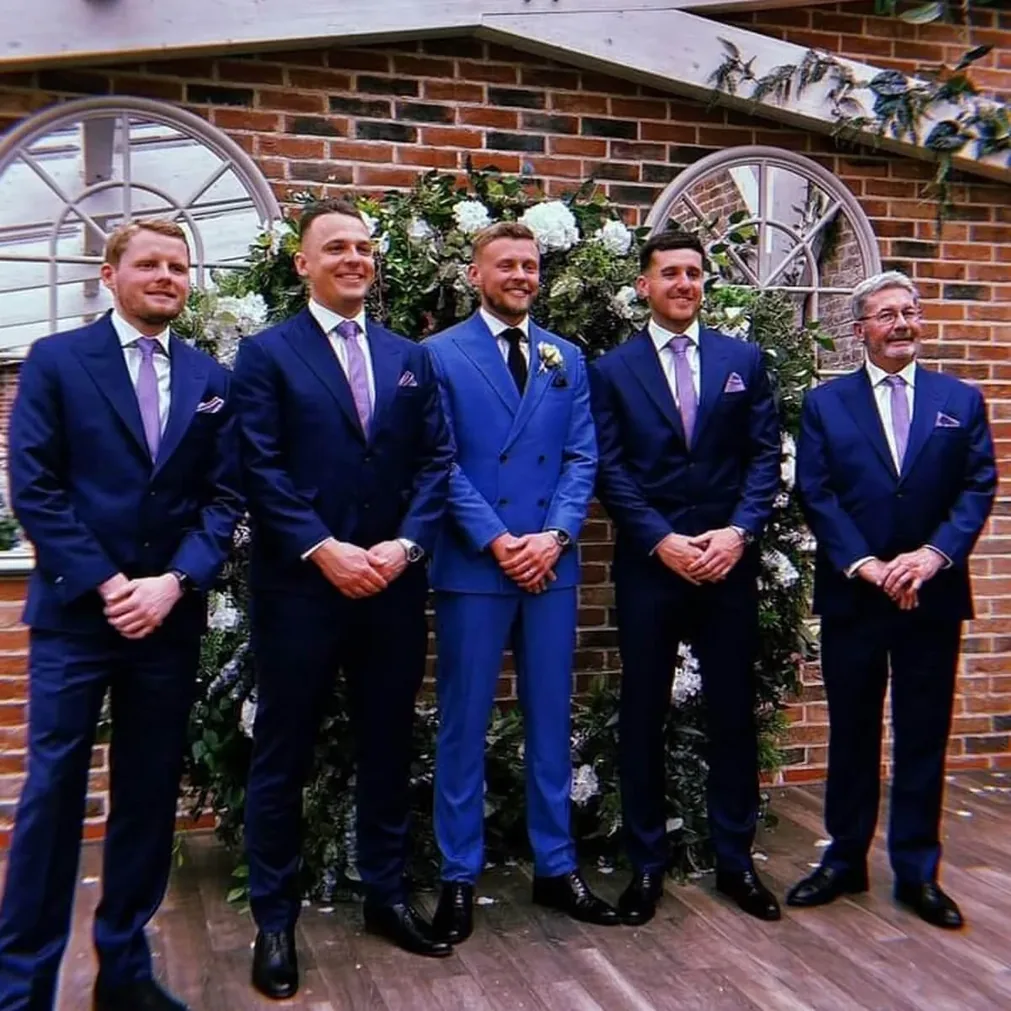 Groom and groomsmen in bespoke blue suits with lilac ties