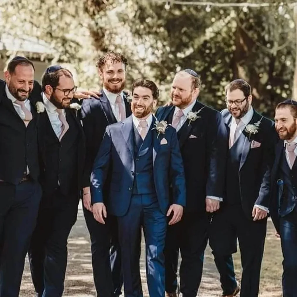 Groom and wedding party in bespoke navy and blue three-piece suits