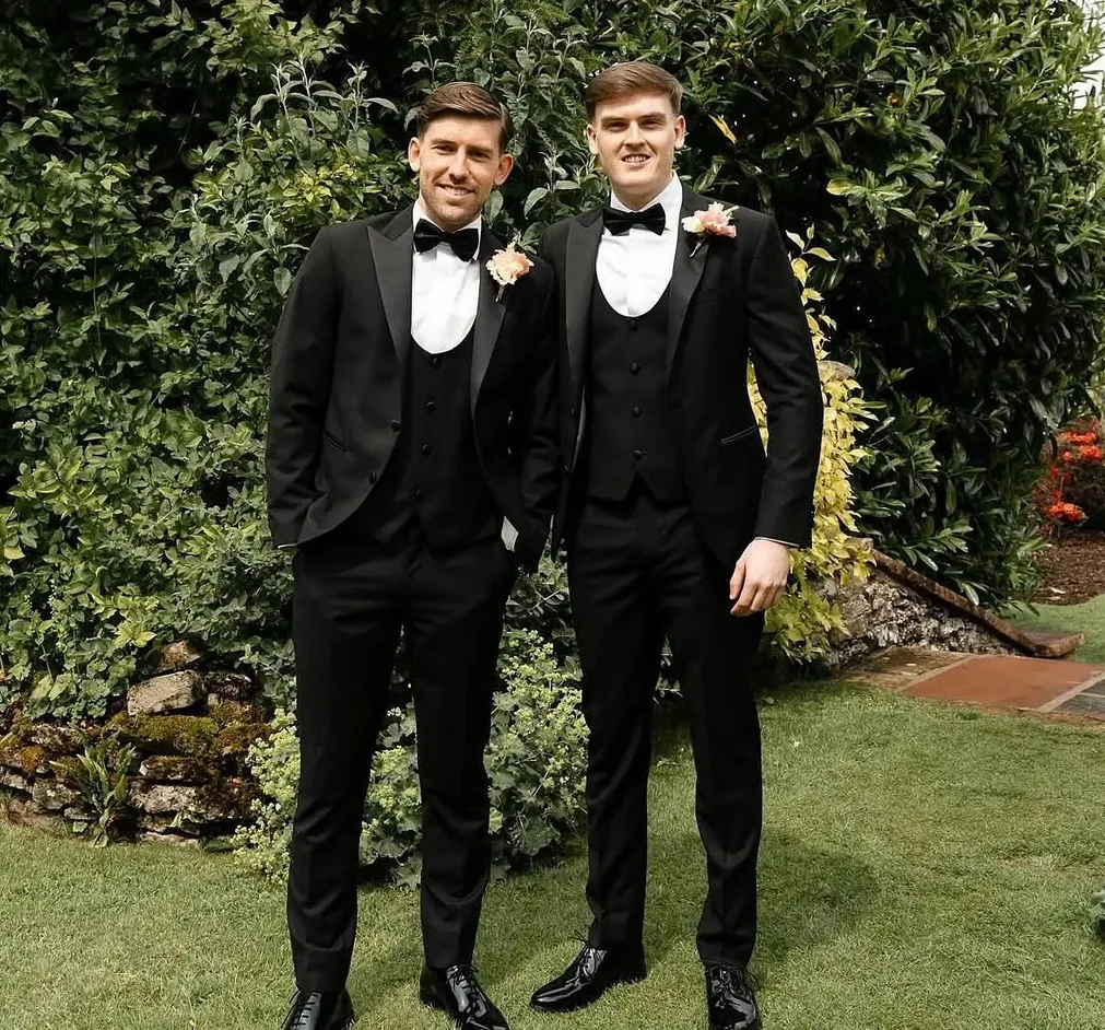 Groom and best man in bespoke black tie three-piece tuxedos