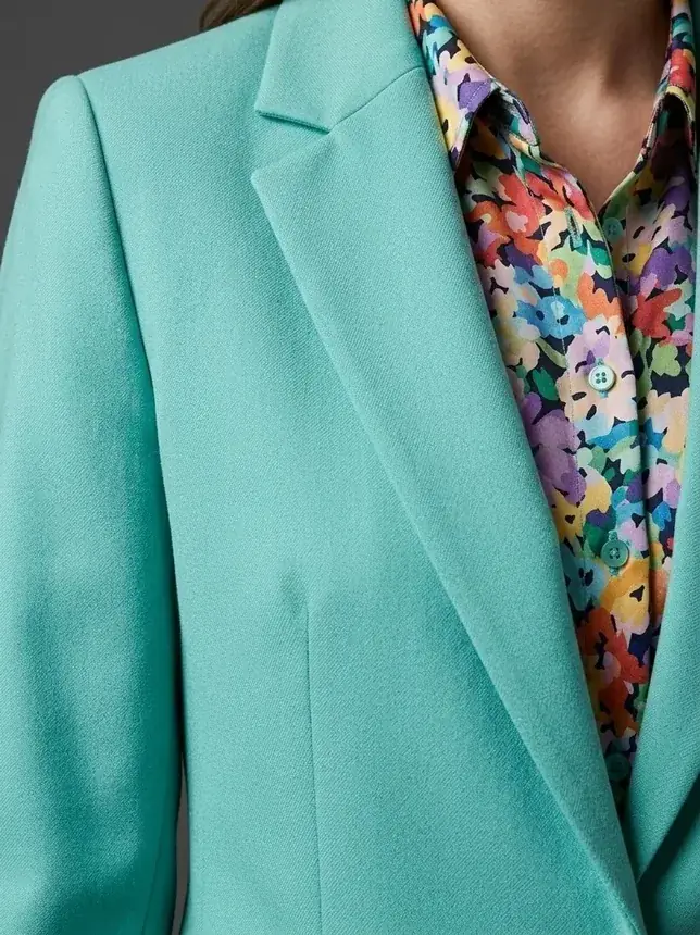 Bespoke women's tailored jacket in soft green wool over a patterned blouse, by Noble Fox